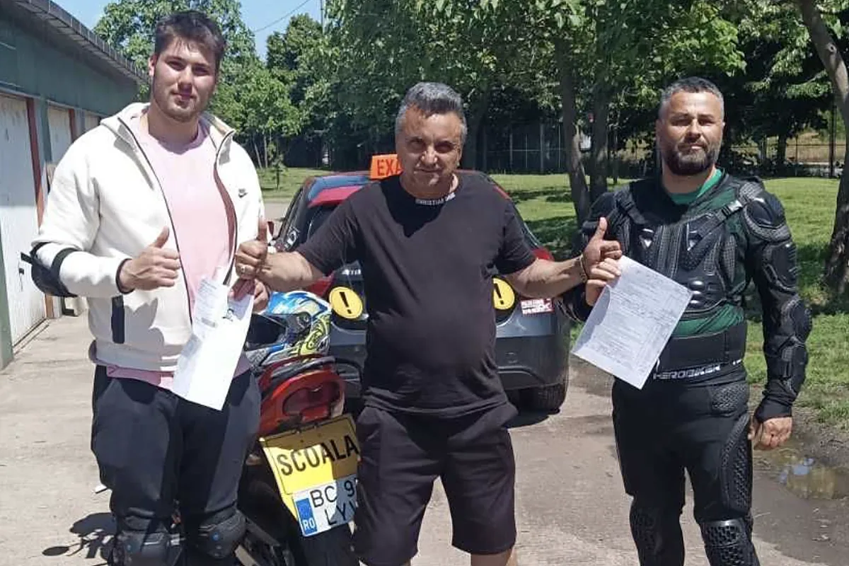 Motocicleta școlii, cu plăcuța galbenă ȘCOALA, alături de instructor și doi cursanți în echipament